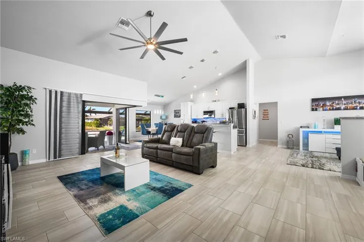 Living room with ceiling fan and high vaulted ceiling
