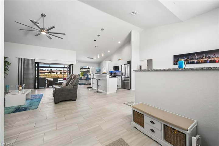 Living room featuring ceiling fan and high vaulted ceiling