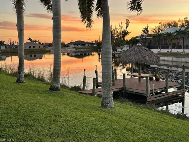 Dock area with a lawn and a water view