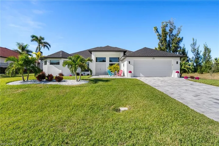 View of front of property featuring a front yard and a garage