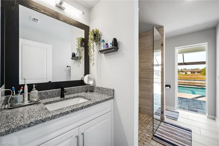 Bathroom with tile patterned flooring, vanity, a textured ceiling, and walk in shower