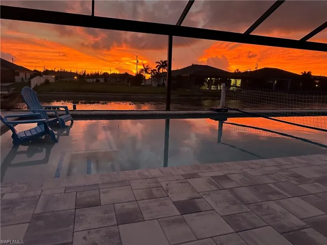 Pool at dusk featuring glass enclosure