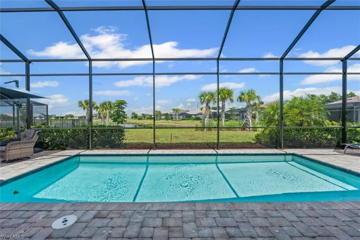 Outdoor pool featuring glass enclosure and a patio area