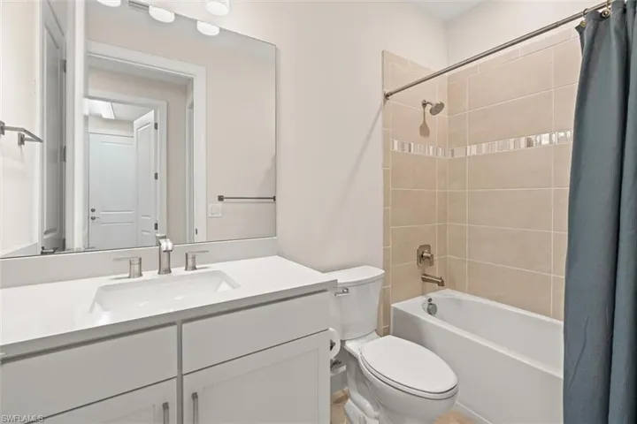 Bathroom with shower / bath combination with curtain and vanity