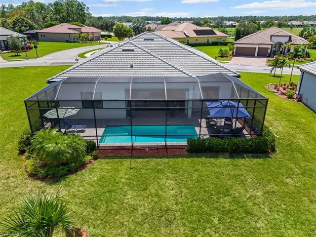 Swimming pool with a residential view, a yard, a lanai, and a patio area
