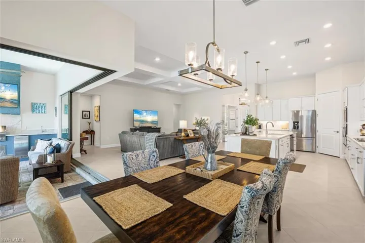 Dining space featuring coffered ceiling, beam ceiling, recessed lighting, a chandelier, and light tile patterned floors
