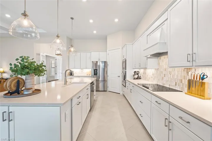 Kitchen with tasteful backsplash, recessed lighting, appliances with stainless steel finishes, light countertops, and white cabinets
