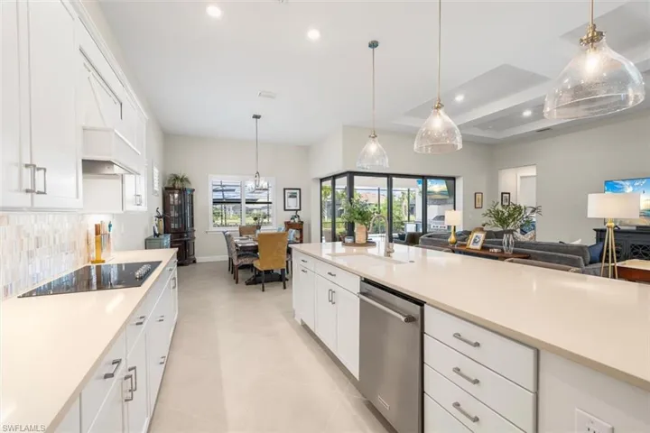 Kitchen featuring open floor plan, stainless steel dishwasher, light countertops, recessed lighting, and plenty of natural light