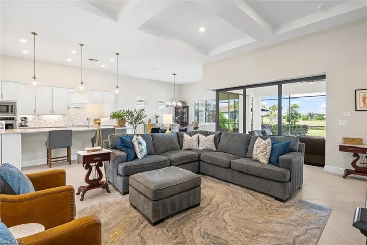 Living area with coffered ceiling, recessed lighting, beamed ceiling, a chandelier, and light tile patterned flooring
