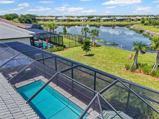 Aerial view of residential area featuring a large body of water and a pool