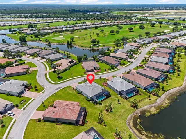 Aerial perspective of suburban area with a large body of water and a golf club