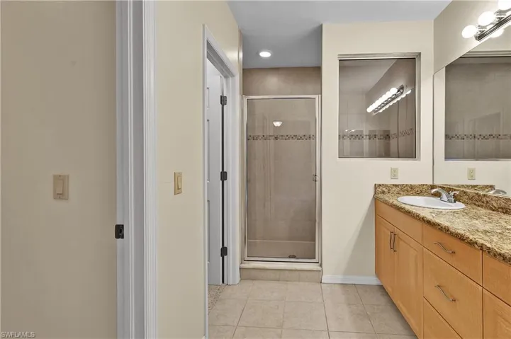 Full bathroom with vanity, light tile patterned flooring, a shower stall, and recessed lighting