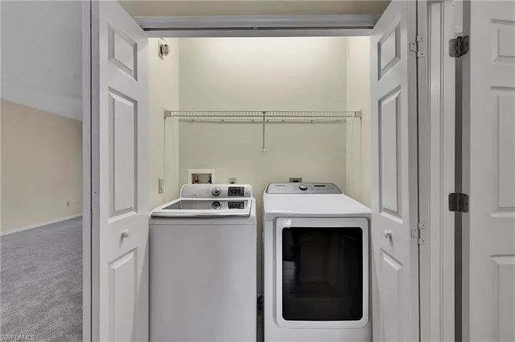 Laundry room featuring carpet and separate washer and dryer