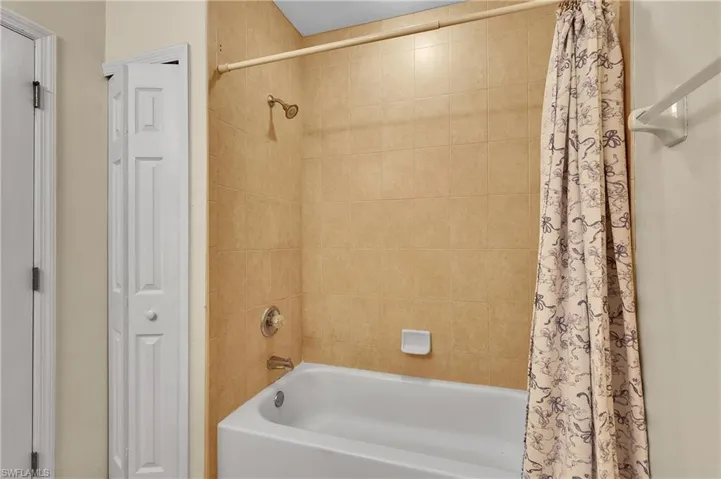 Bathroom with shower / bath combo and a closet