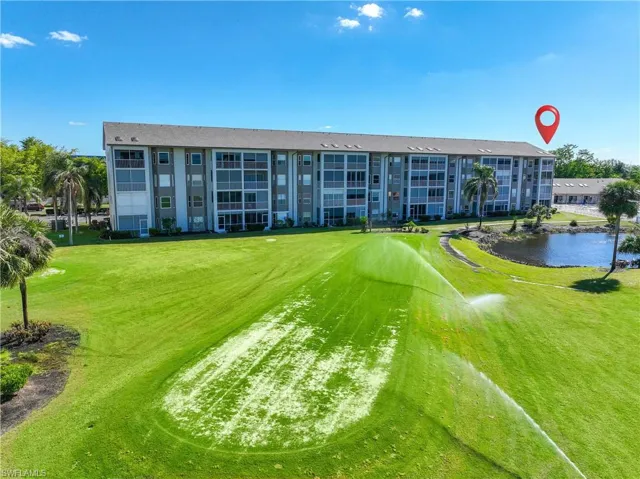 View of community with view of golf course, a water view, and a yard