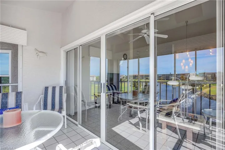 Balcony featuring outdoor dining space, ceiling fan, a water view, and a sunroom