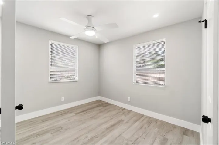 Empty room with a ceiling fan, wood finished floors, baseboards, and recessed lighting