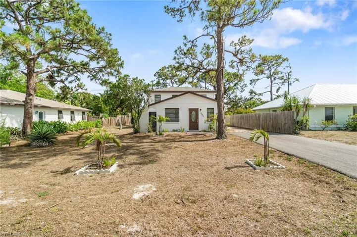 View of front of house with fence and stucco siding