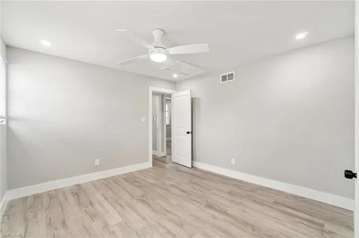 Empty room with wood finished floors, a ceiling fan, baseboards, and recessed lighting