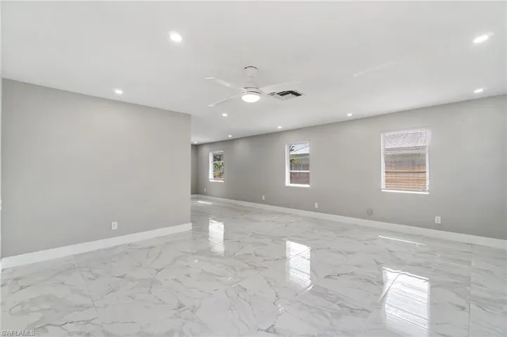 Empty room featuring recessed lighting, ceiling fan, baseboards, and light marble finish flooring