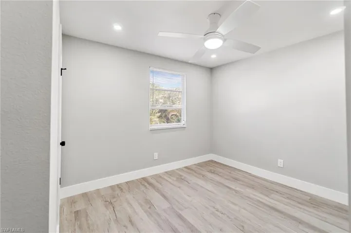 Unfurnished room with wood finished floors, ceiling fan, baseboards, and recessed lighting
