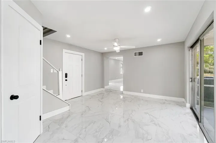 Empty room with baseboards, light marble finish floors, recessed lighting, a ceiling fan, and stairs