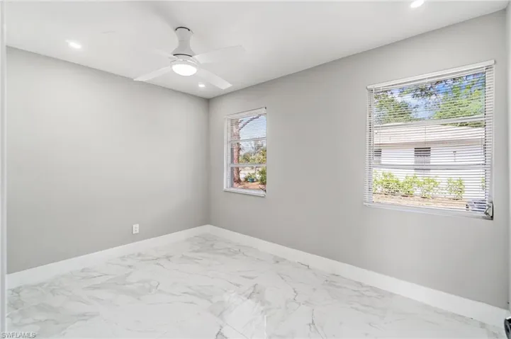 Empty room with baseboards, marble look tile flooring, recessed lighting, and ceiling fan