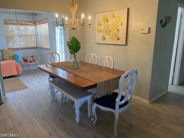 Dining area with hardwood / wood-style floors and a chandelier