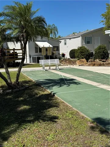 View of property's community featuring a yard and shuffleboard