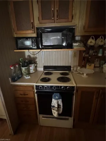 Kitchen with range with electric stovetop, light countertops, and wood finished floors