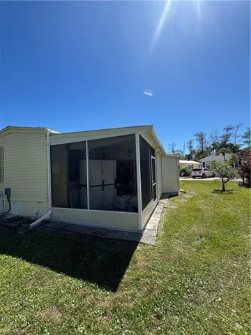 Back of property featuring a yard and a sunroom