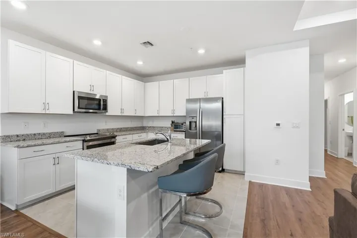This kitchen has ample cabinetry, granite countertops, and stainless appliances.