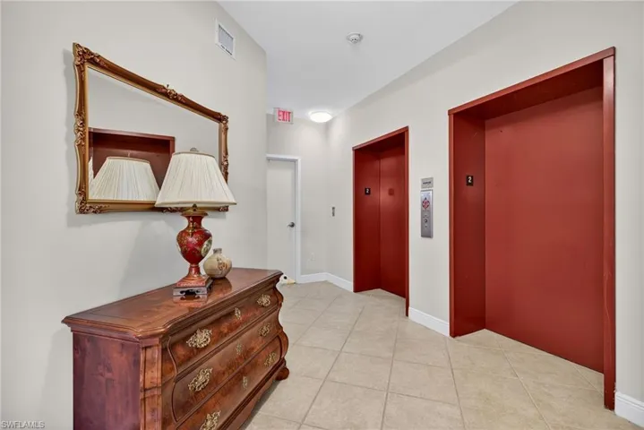 Hallway with elevator and light tile patterned floors