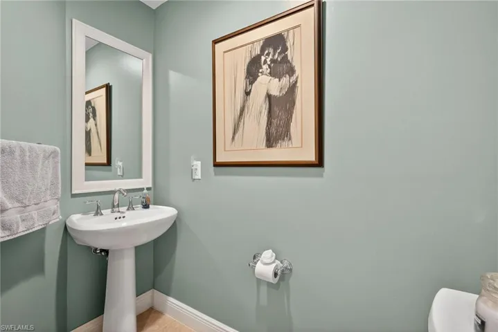Half bath featuring toilet and baseboards