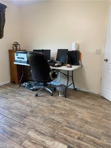 Home office featuring light wood-style flooring and baseboards