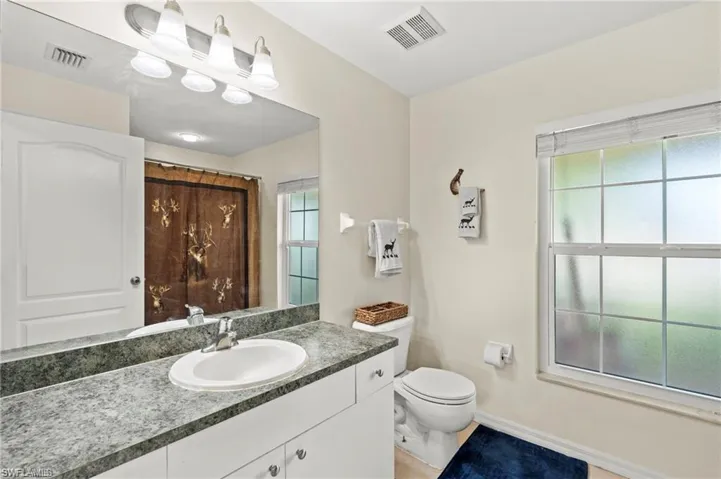 Bathroom featuring vanity, healthy amount of natural light, and light tile patterned flooring