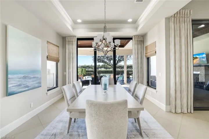 Dining space with hanging lights, crown molding, and light tile patterned floors