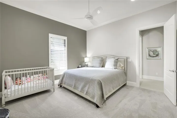 Bedroom featuring crown molding, light carpet, and a ceiling fan
