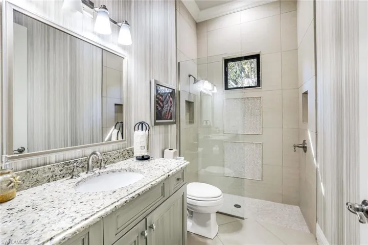 Bathroom featuring vanity, a walk in shower, and light tile patterned floors