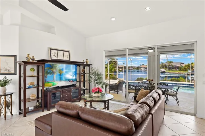 Living room featuring a ceiling fan, light tile patterned floors, vaulted ceiling, and recessed lighting