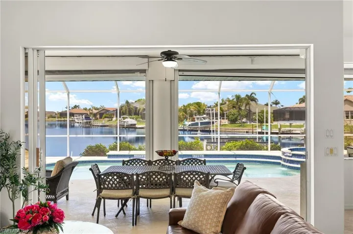 Dining space featuring ceiling fan, a water view, a sunroom, and healthy amount of natural light