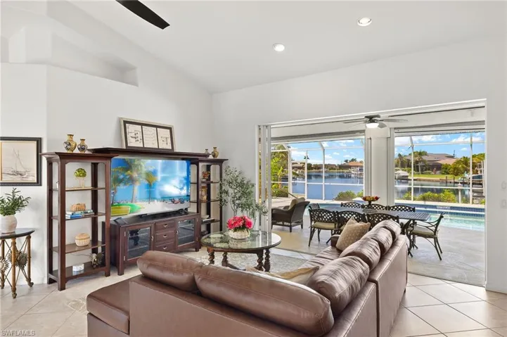 Living area with a ceiling fan, light tile patterned floors, vaulted ceiling, and recessed lighting