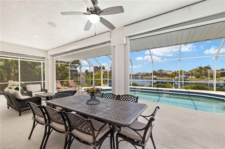 Sunroom with a ceiling fan, an outdoor hangout area, a water view, and outdoor dining space