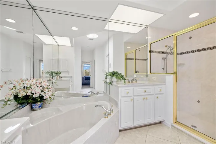 Bathroom featuring a stall shower, a bath, vanity, tile patterned flooring, and recessed lighting