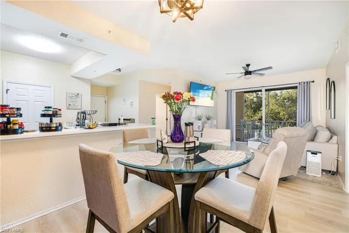 Dining area with light wood finished floors, a ceiling fan, and a chandelier