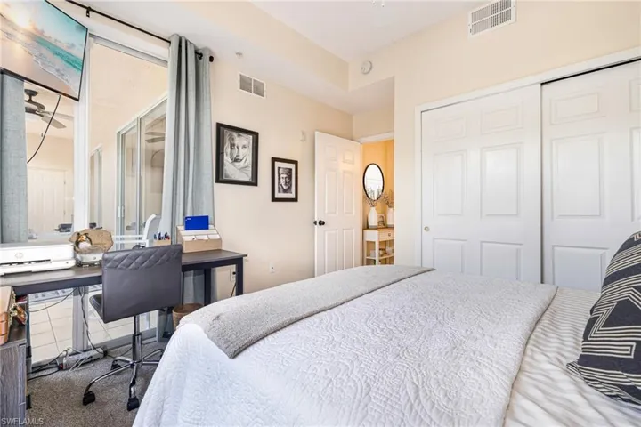 Carpeted bedroom with a desk and a closet