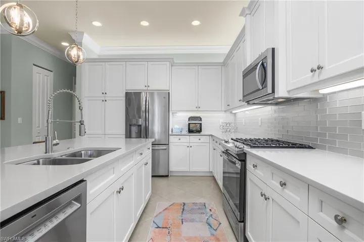 Kitchen with stainless steel appliances, recessed lighting, white cabinetry, light tile patterned flooring, and tasteful backsplash