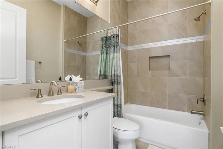 Bathroom featuring shower / bath combination with curtain and vanity