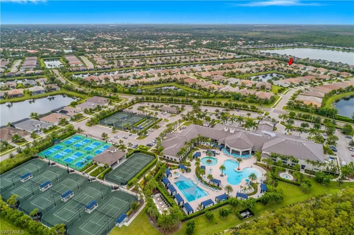Aerial perspective of suburban area with a nearby body of water and a pool