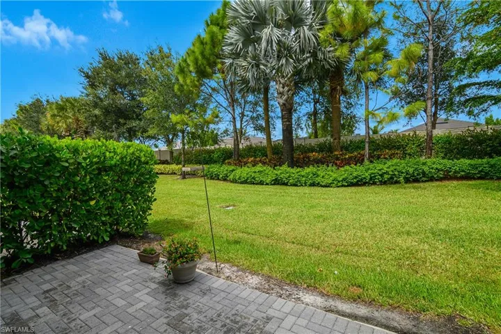 View of grassy yard featuring a patio